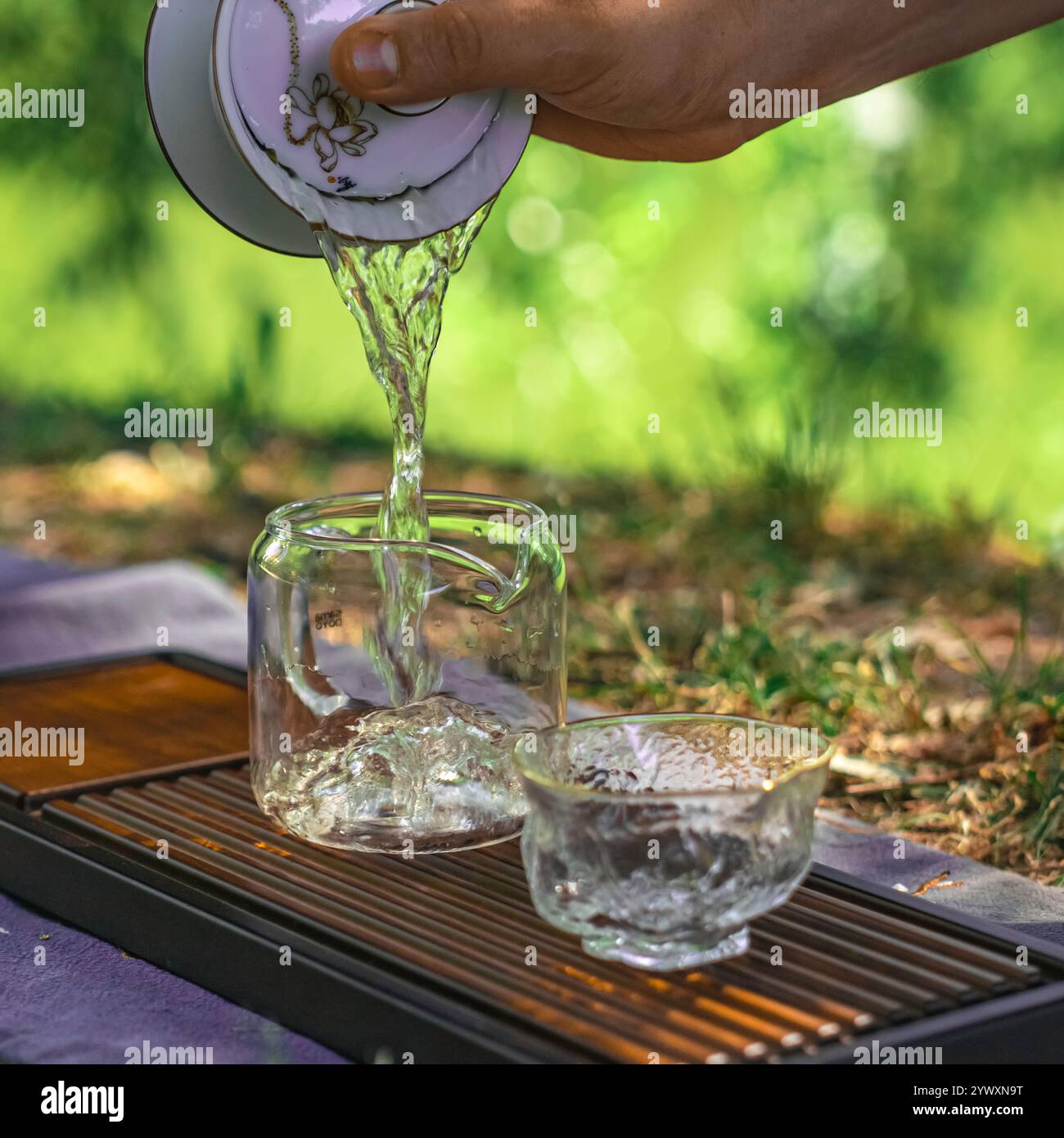 Making Tea Outdoors Enjoy the tranquility of pouring tea outdoors in a beautiful ...