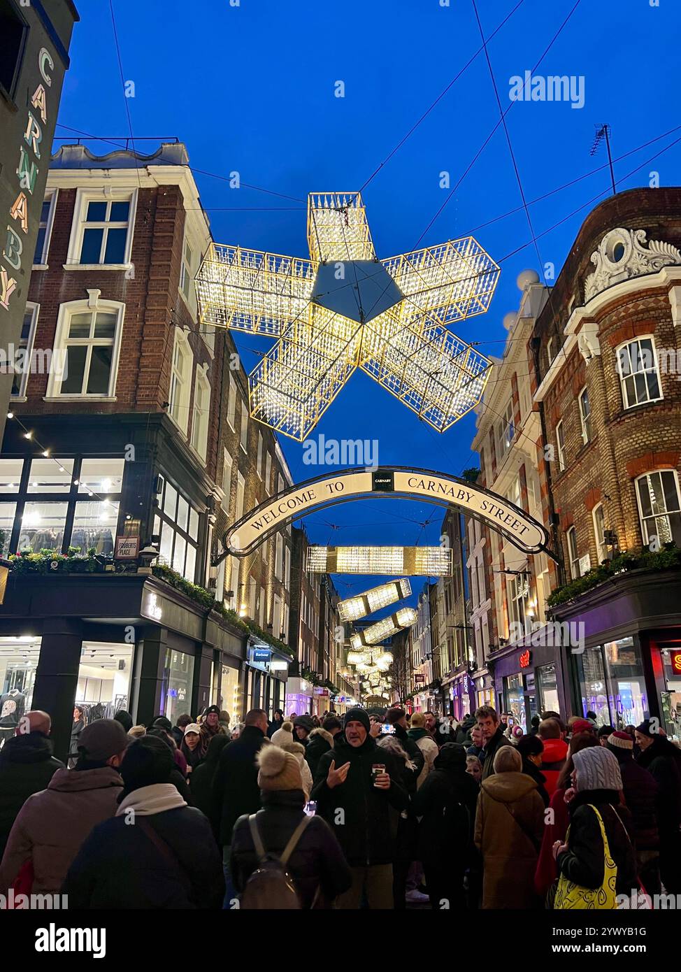 Central London, Soho, Carnaby Street Holiday lights at dusk with tourists and shoppers in the streets.  Blue Hour. Stock Photo