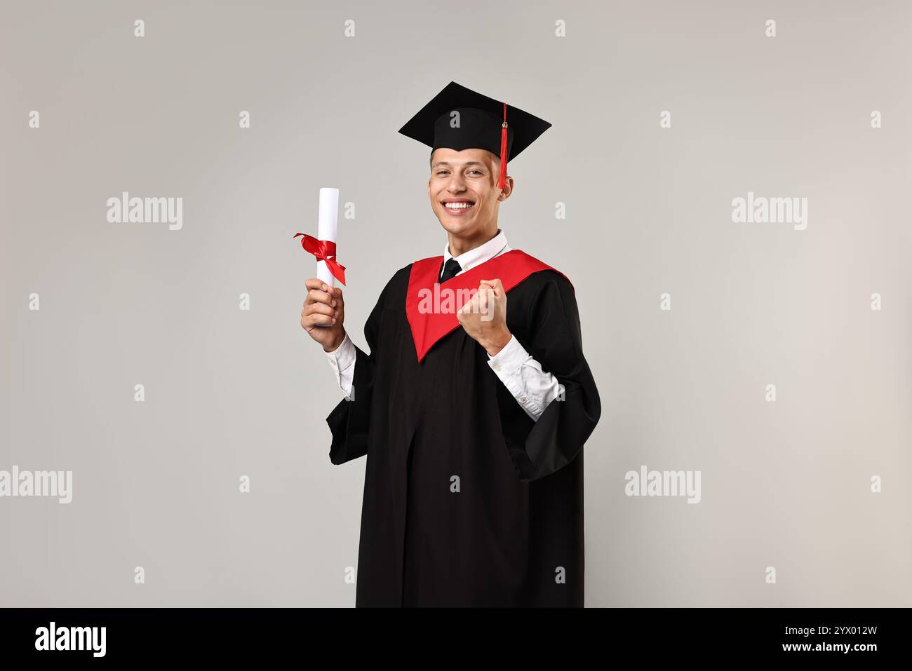 Happy student with diploma after graduation on grey background Stock ...
