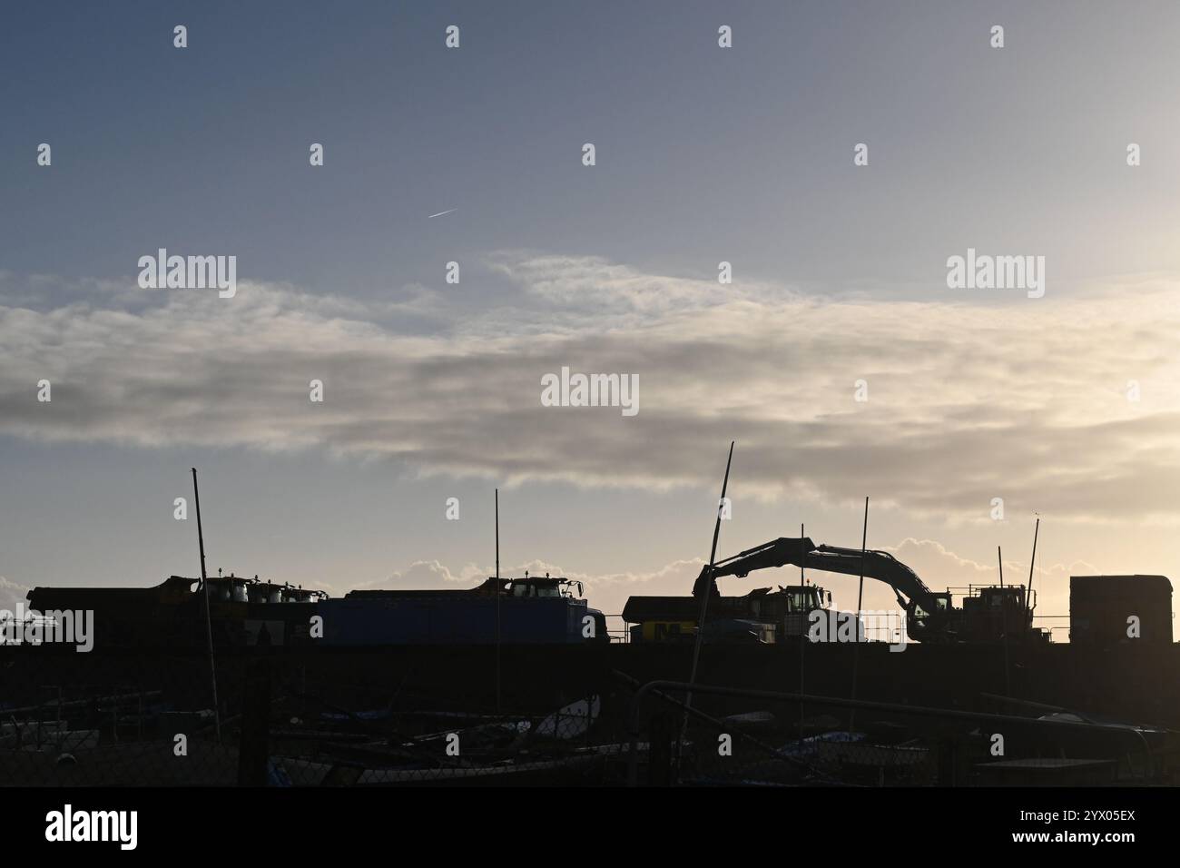 silhouette of rock trucks and loader Stock Photo