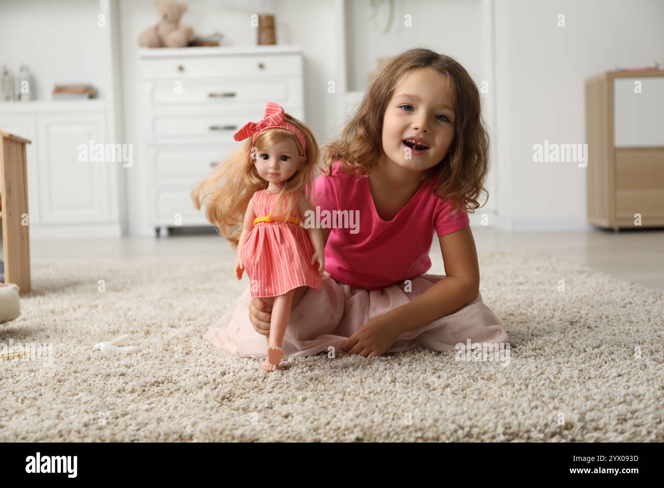 Cute little girl playing with her doll on floor at home Stock Photo - Alamy