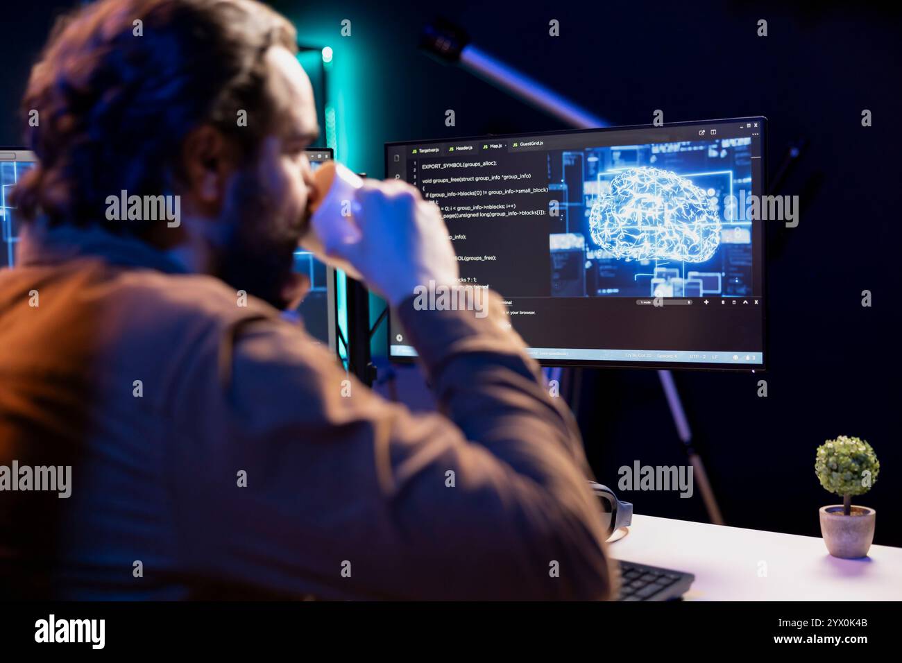 Programmer drinking coffee and doing maintenance on artificial intelligence neural networks computerized model. Tech support expert enjoying hot beverage while checking up on AI systems Stock Photo