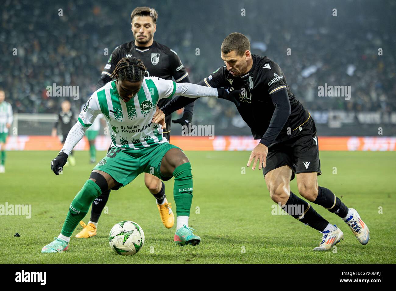 St. Gallen, Switzerland. 12th Dec, 2024. St. Gallen, Switzerland, December 12st 2024: A duel between Felix Mambimbi (18 FCSG) and João Mendes (13 Guimarães) during the UEFA Conference League football match between FC St. Gallen and Vitória SC at Kybunpark in St. Gallen, Switzerland. Philipp Kresnik (Philipp Kresnik/SPP) Credit: SPP Sport Press Photo. /Alamy Live News Stock Photo