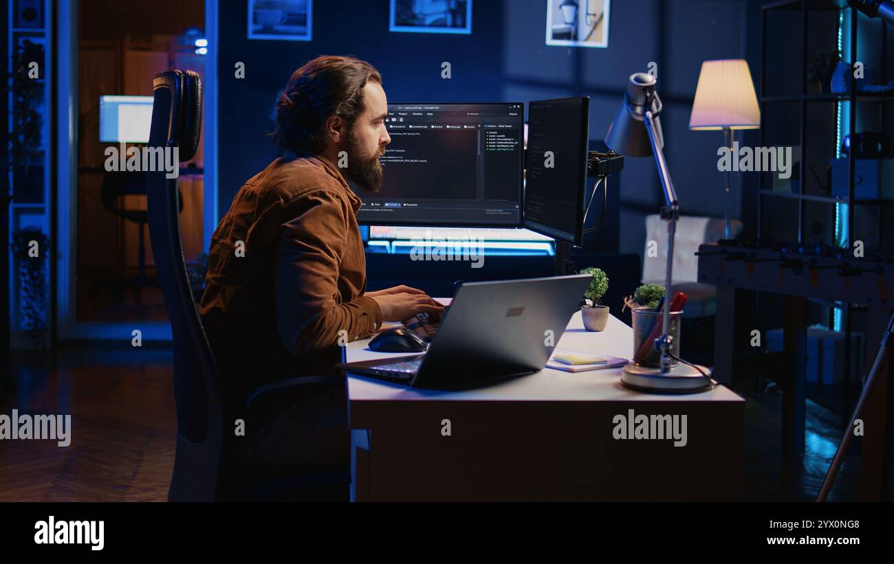 Developer pressed by deadline, drinking coffee and doing multitasking to finish developing PC code. Caffeinated IT specialist solving database error using multiple desktop and laptop screens, camera B Stock Photo