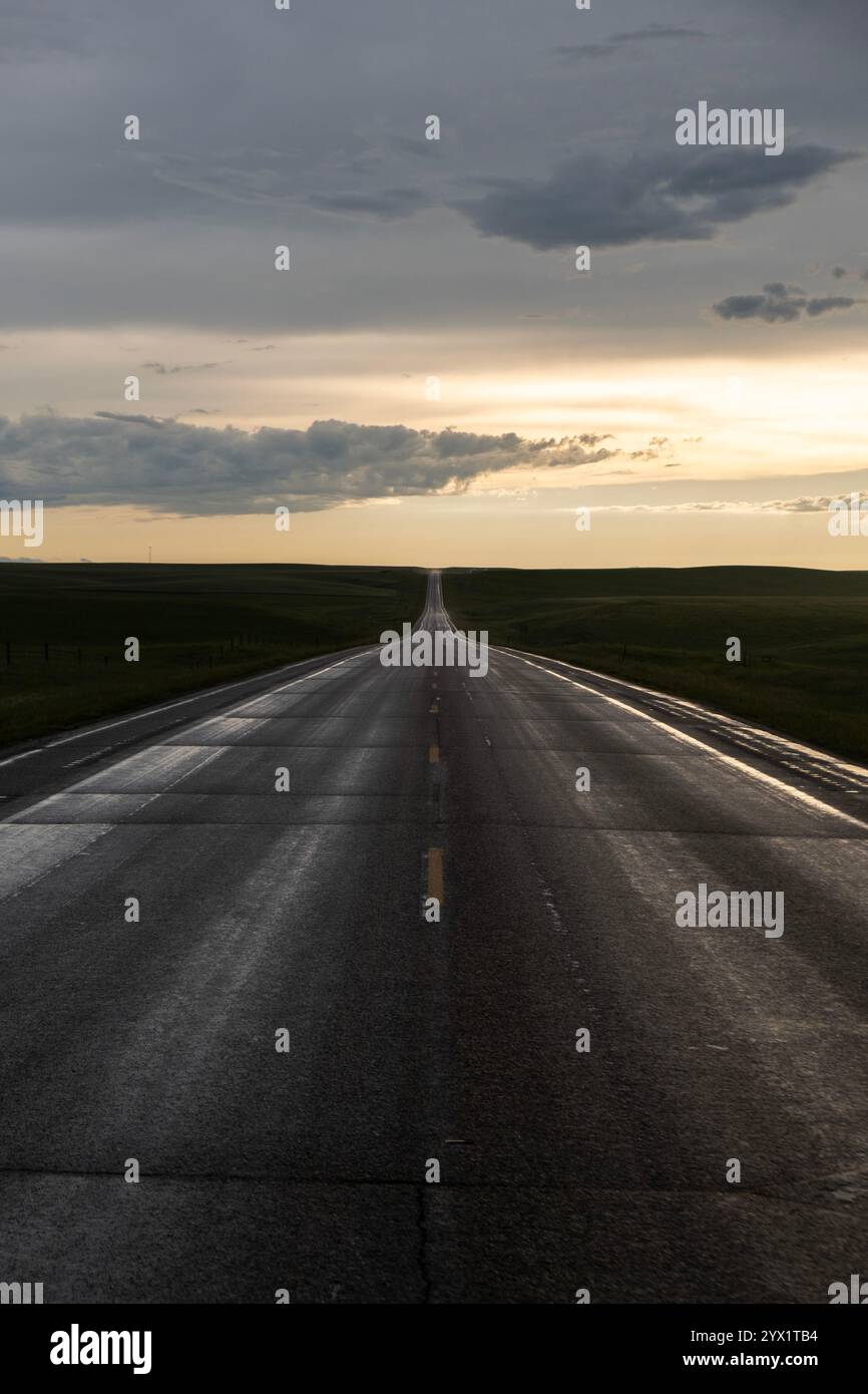 Eerie light following a storm looking down a lonely desolate stretch of highway in South Dakota Stock Photo