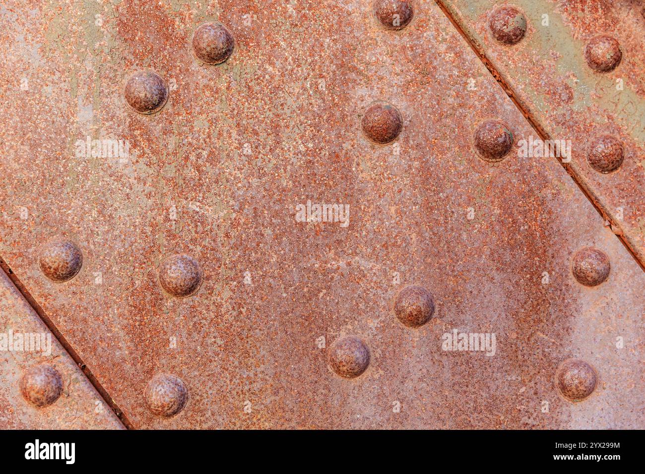 The image is of a rusted metal surface with many small holes and bumps ...