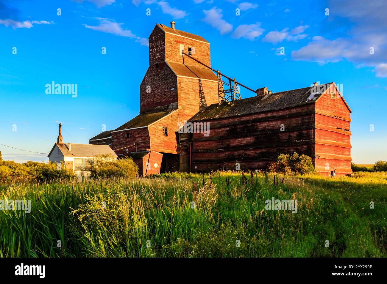 A red barn with a white house next to it. The barn is old and the house ...