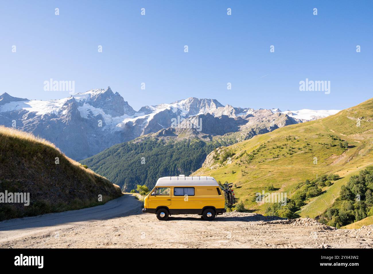 Retro camper van parked in the forest with high mountains in the ...