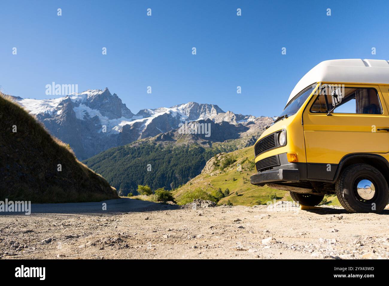Retro camper van parked in the forest with high mountains in the ...
