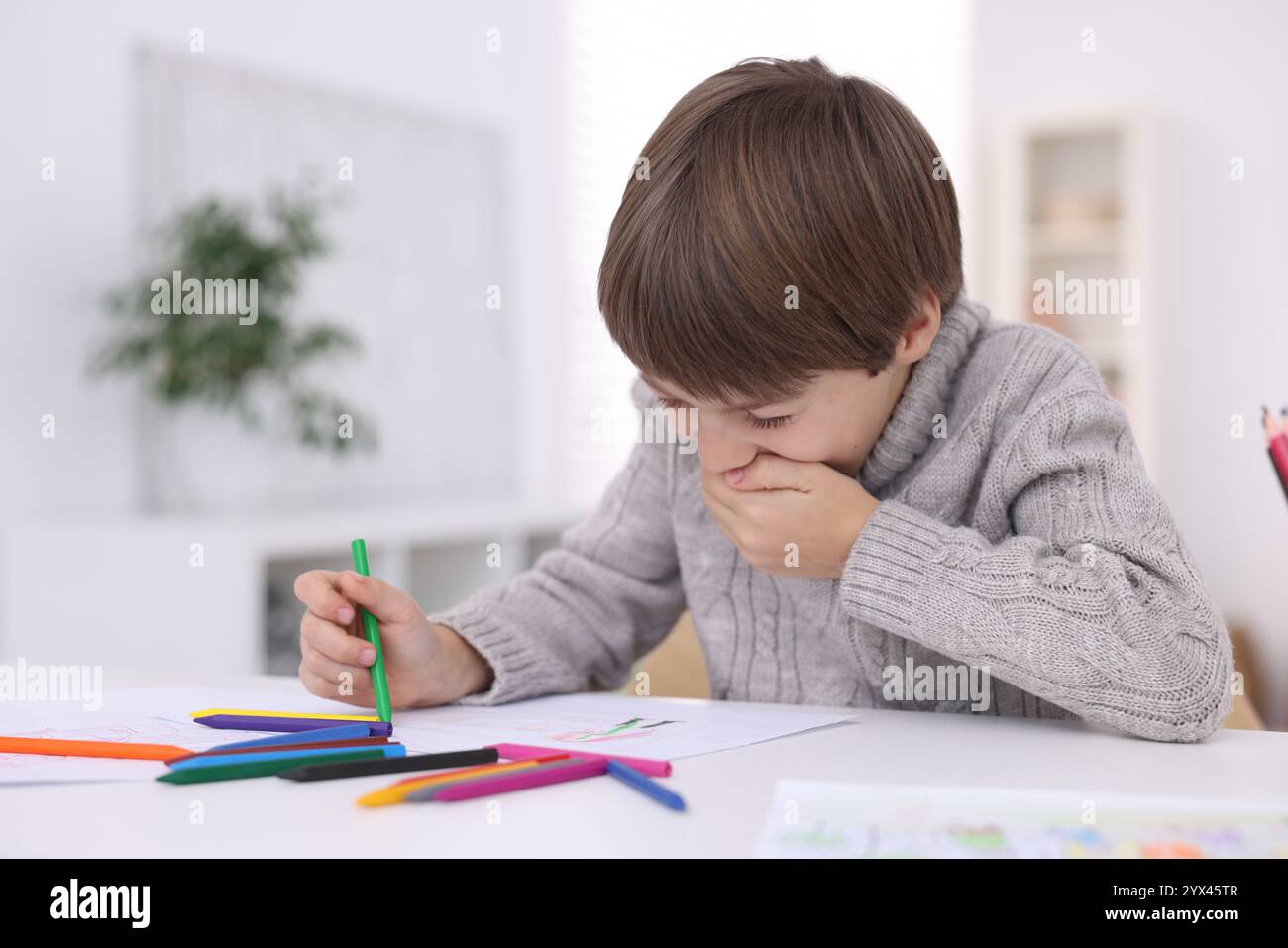 Cute boy drawing at white table in kindergarten Stock Photo - Alamy