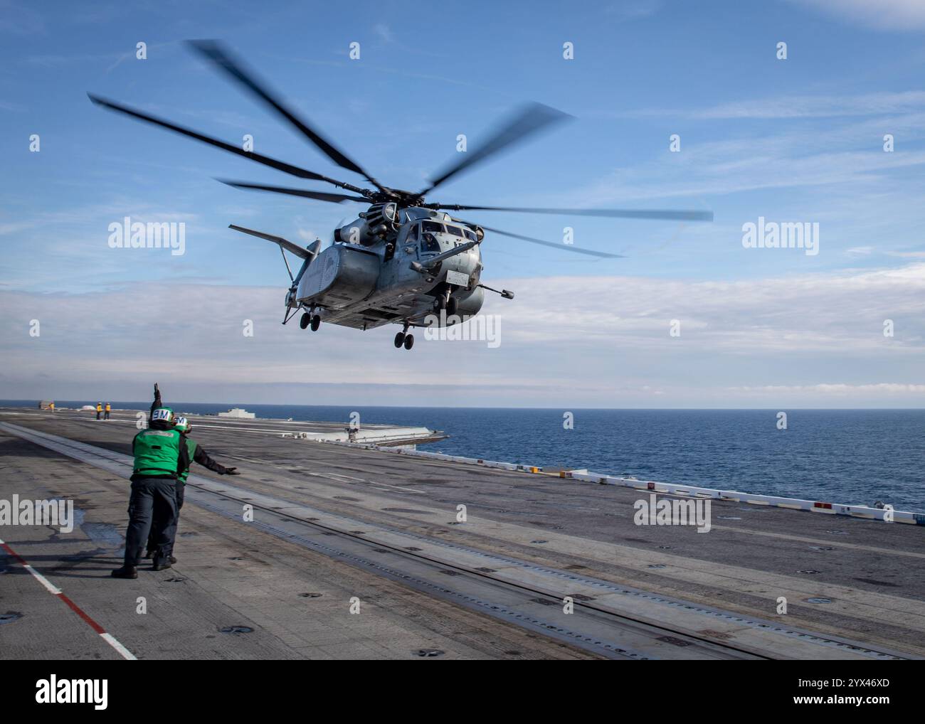 241210-N-SK738-1102 ATLANTIC OCEAN (Dec. 10, 2024) Sailors assigned to the Nimitz-class aircraft carrier USS George H.W. Bush (CVN 77) signal an MH-53 Stock Photo