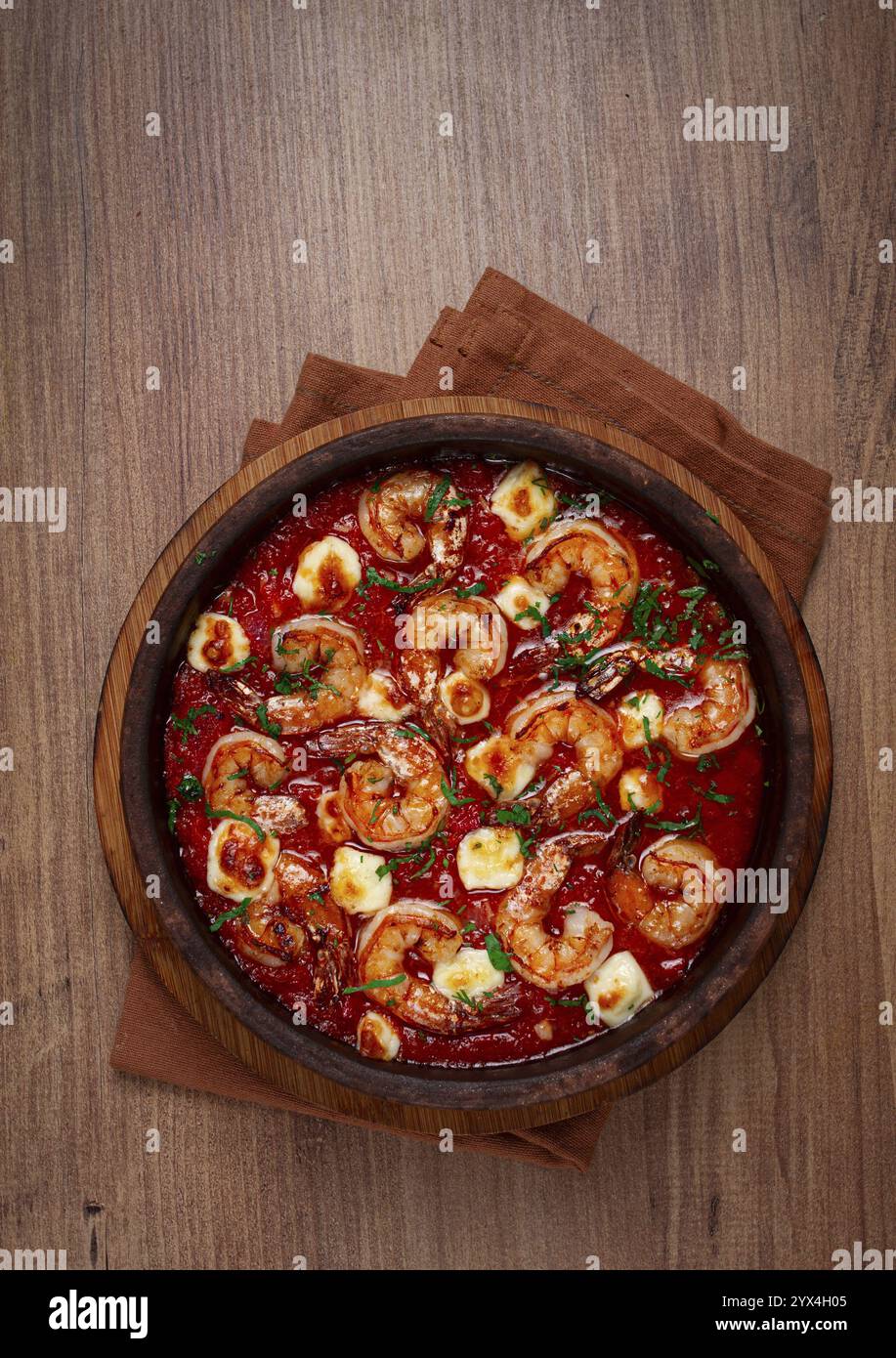 Saganaki with shrimp, in a clay pan, Greek dish, shrimp in tomato sauce ...