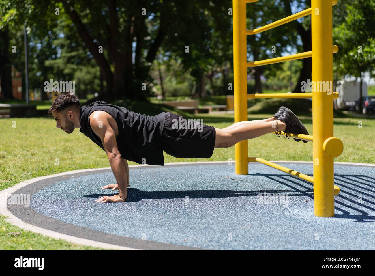 Young man strengthening his body with push-ups in the park Stock Photo ...