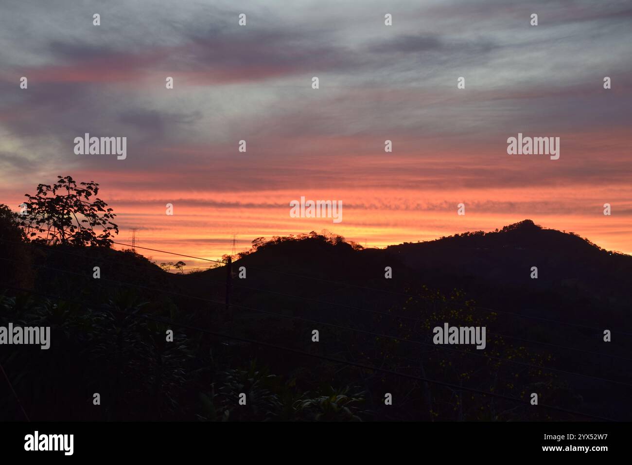 Paisaje atardecer naranja con sombra de montañas y arboles Stock Photo