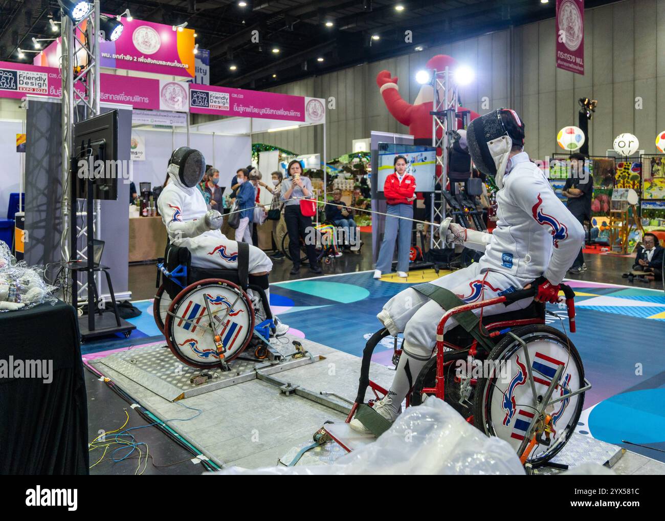 Two wheelchair fencers are seen with their foils during a competition, at the Thailand Friendly Design Expo 2024, at The Bangkok International Trade and Exhibition (BITEC). The Thailand Friendly Design Expo 2024 aims to create a more inclusive and sustainable society for the elderly and people with disabilities in Thailand through design and technology. Founded by Krisana Lalai, a Thai journalist and human rights activist, the event promotes accessibility across various sectors. After a car accident in 1997 left him paralyzed, Krisana dedicated his life to advocating for inclusive design and e Stock Photo