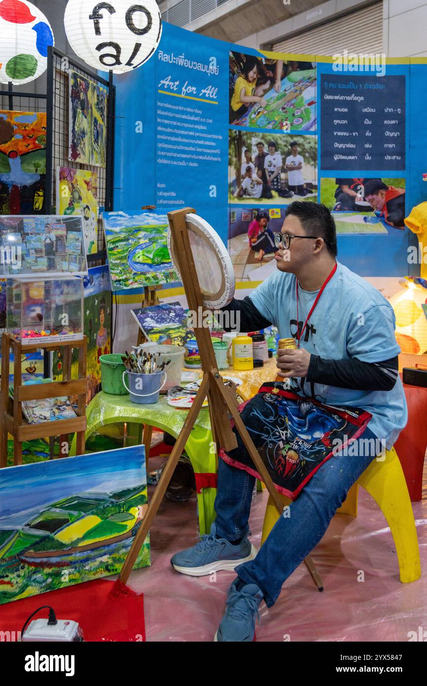 A person with autism is seen painting, at the Thailand Friendly Design Expo 2024, at The Bangkok International Trade and Exhibition (BITEC). The Thailand Friendly Design Expo 2024 aims to create a more inclusive and sustainable society for the elderly and people with disabilities in Thailand through design and technology. Founded by Krisana Lalai, a Thai journalist and human rights activist, the event promotes accessibility across various sectors. After a car accident in 1997 left him paralyzed, Krisana dedicated his life to advocating for inclusive design and equal rights, raising awareness t Stock Photo