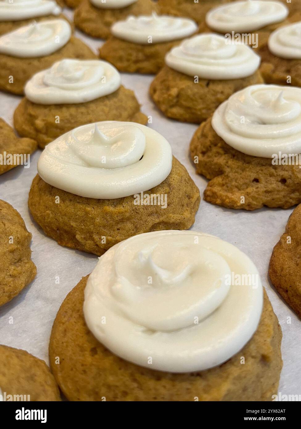 Freshly Baked Pumpkin Cookies with Creamy Frosting on Parchment Paper - Smartphone Captured Stock Image