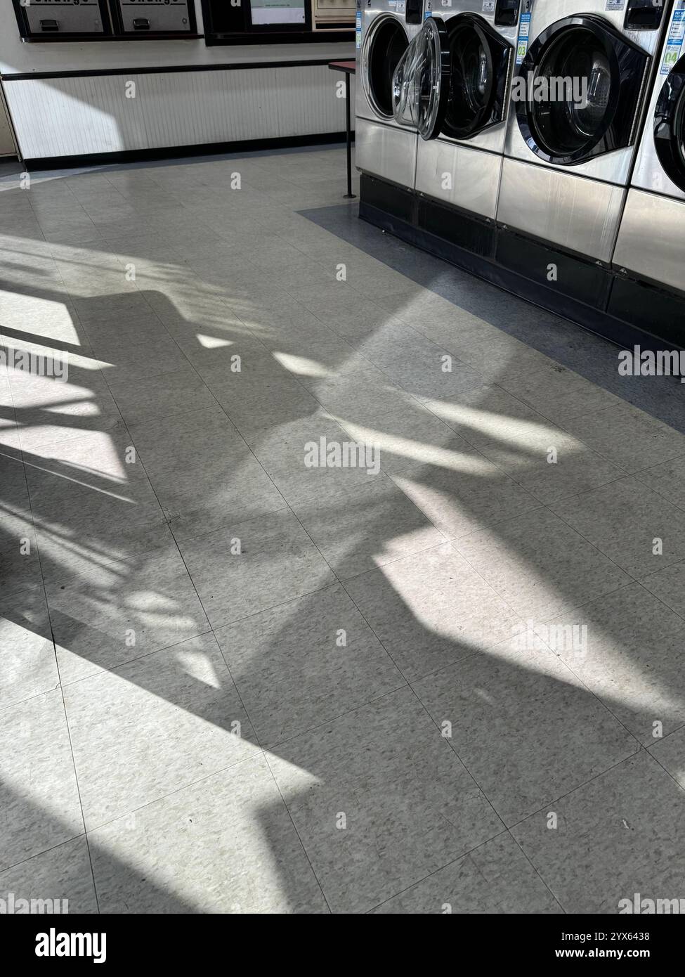 Light and shadow cast onto the floor at the Elmwood Laundromat in Berkeley, California. - Smartphone Captured Stock Image