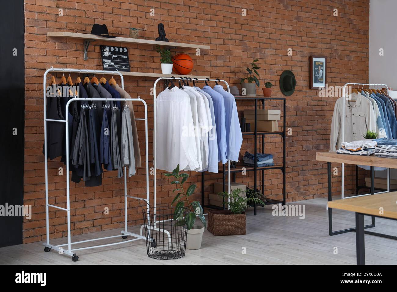 Interior of men's clothing store with racks and shelf unit Stock Photo ...