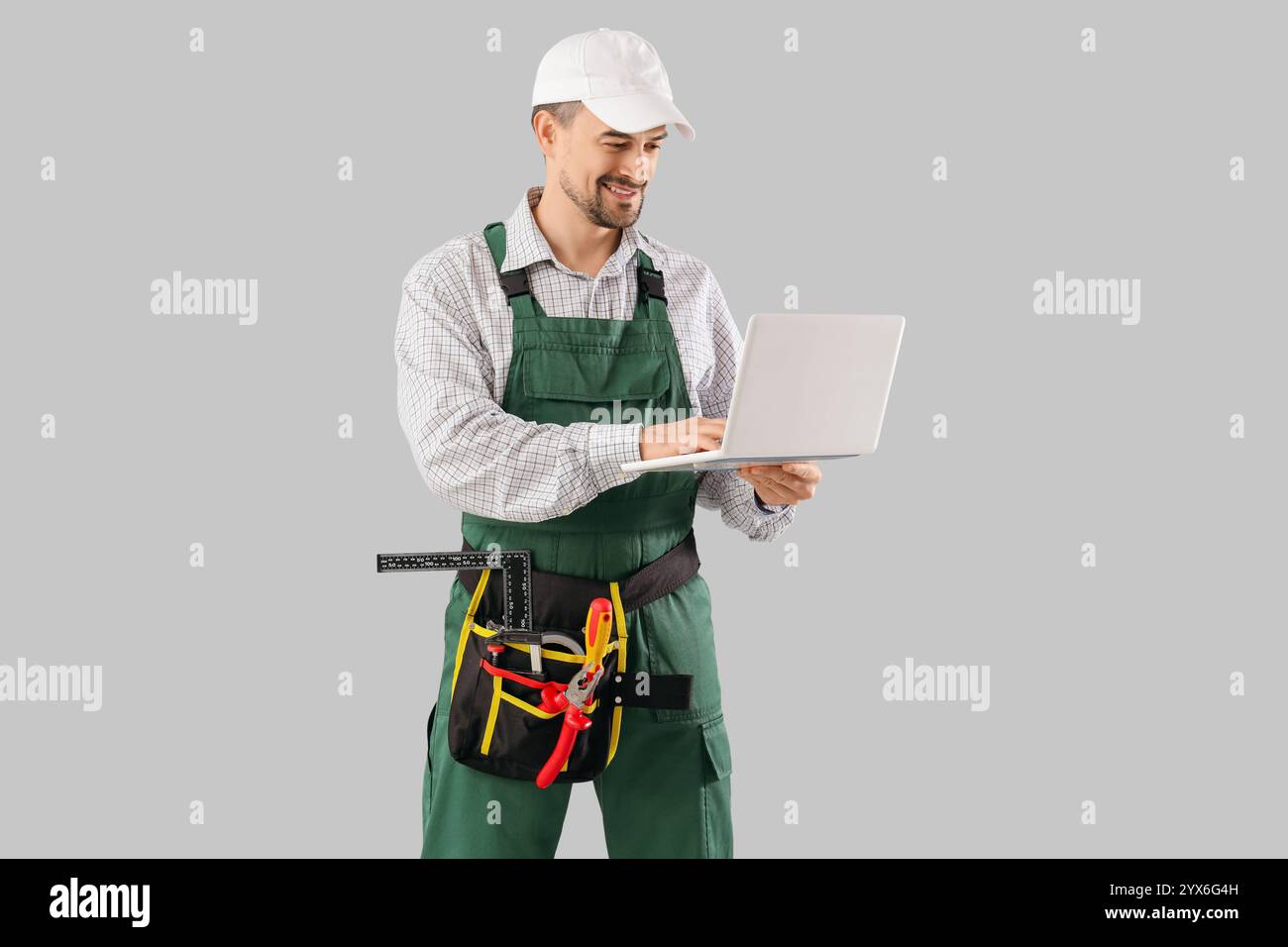 Male technician using laptop on light background Stock Photo