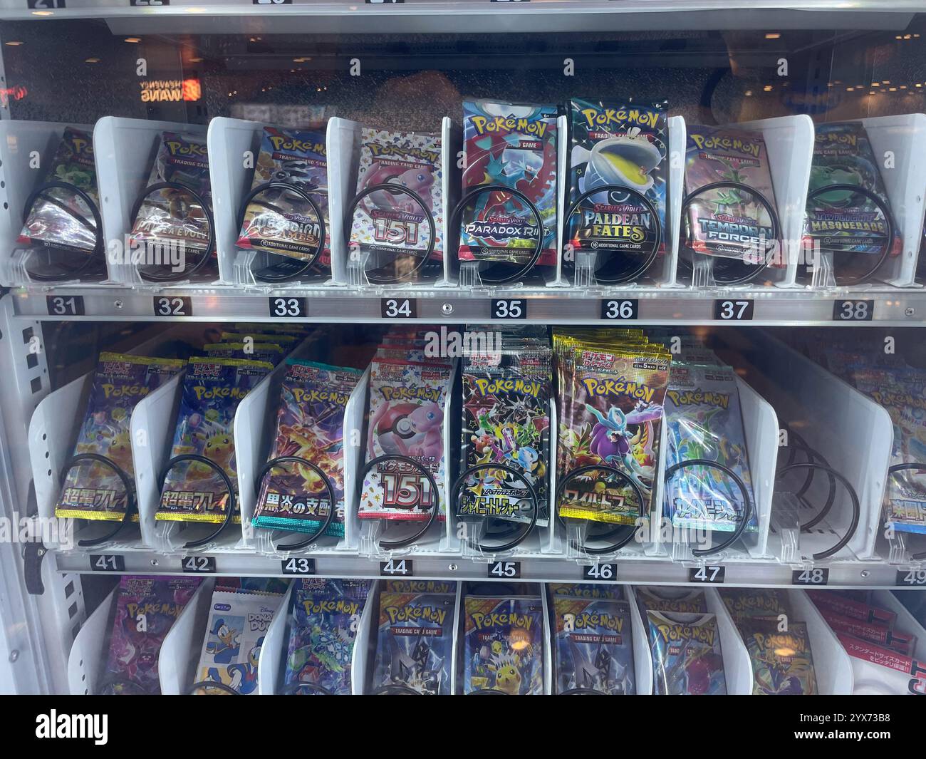 vending machine containing Pokemon trading card booster packs organized into numbered slots. The packaging features vibrant designs with Pokemon chara - Smartphone Captured Stock Image