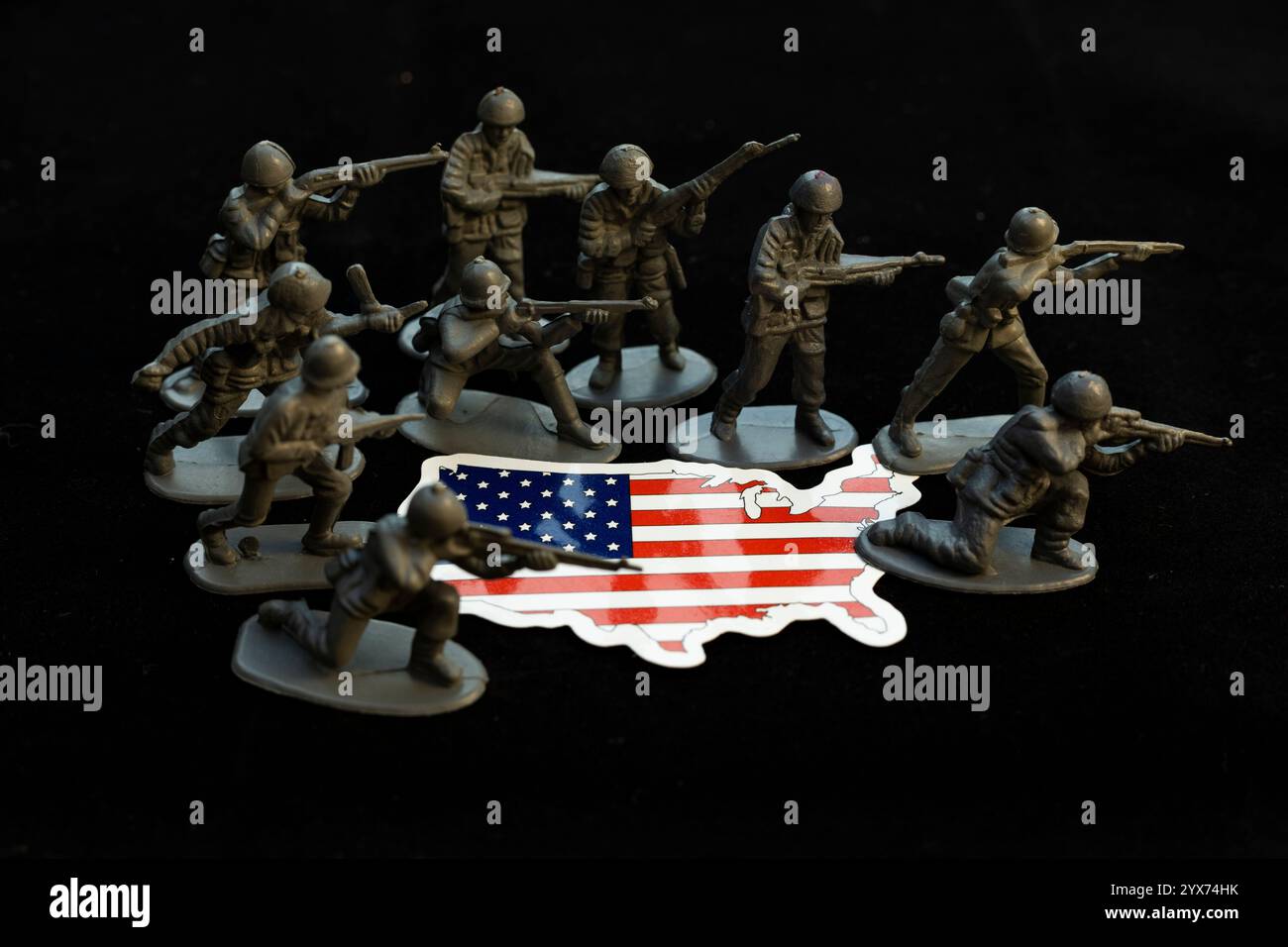 Army figures surrounding USA map flag on black background. Defense concept. Stock Photo