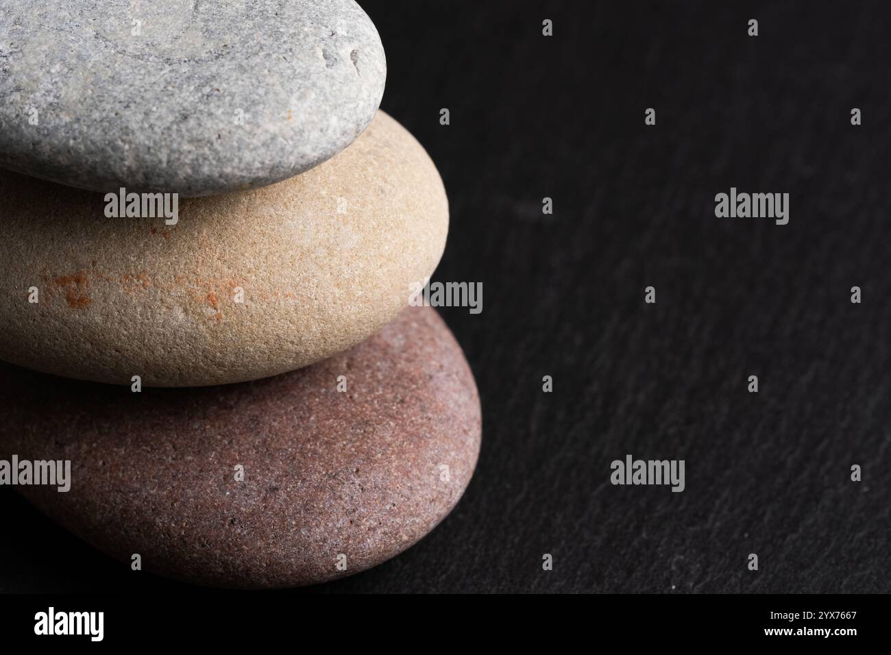 Stack of pebbles on black stone background. Zen concept Stock Photo