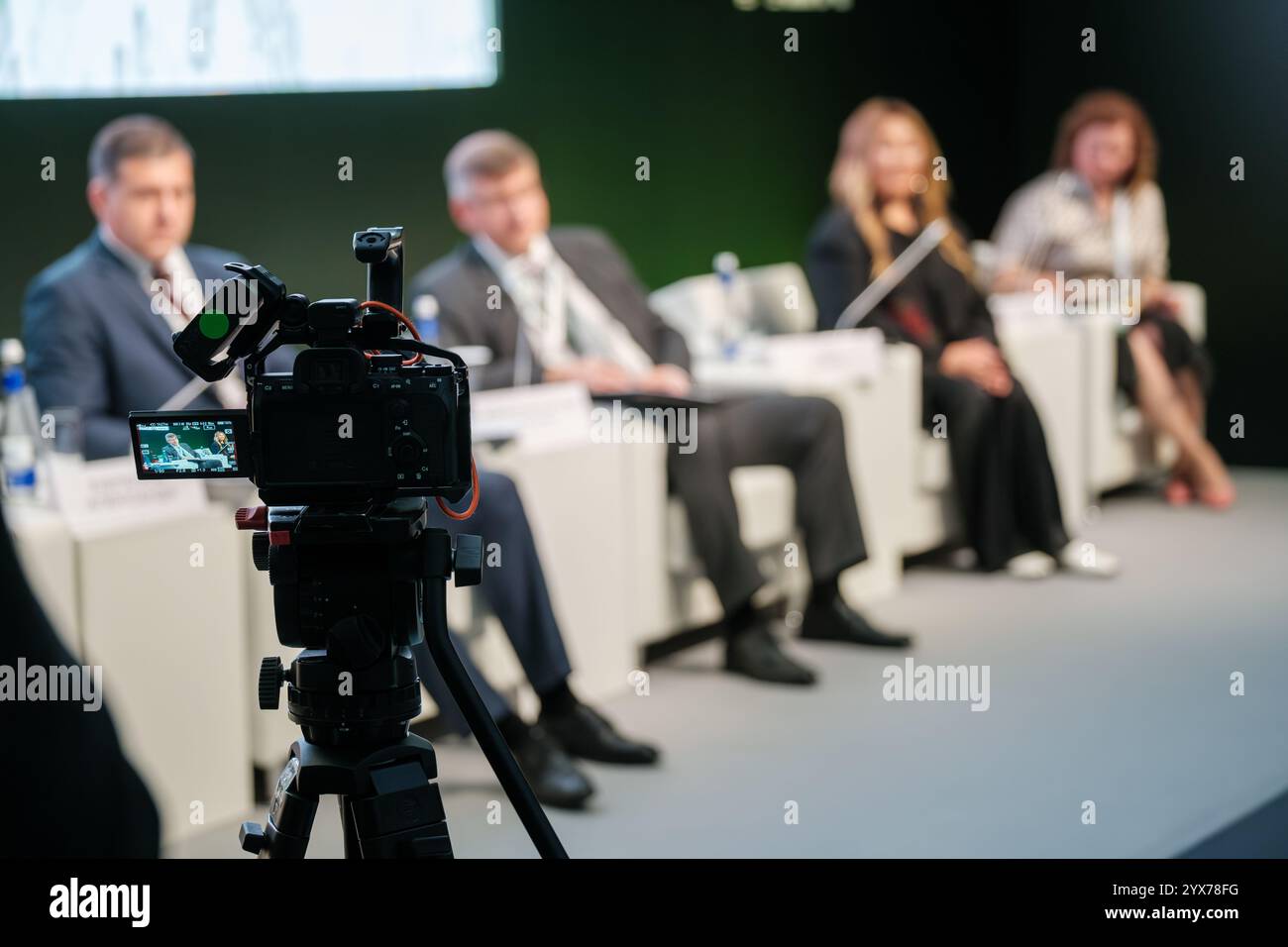 Conference Panel Recording Camera on tripod films panel discussion with speakers in professional ...