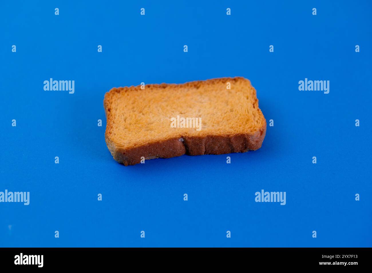 Crispy, golden rusk on vibrant blue backdrop. Perfect for food blogs ...