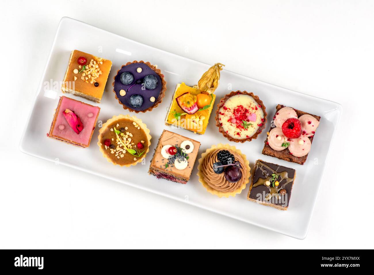 Many various cakes on plate on white background. Stock Photo