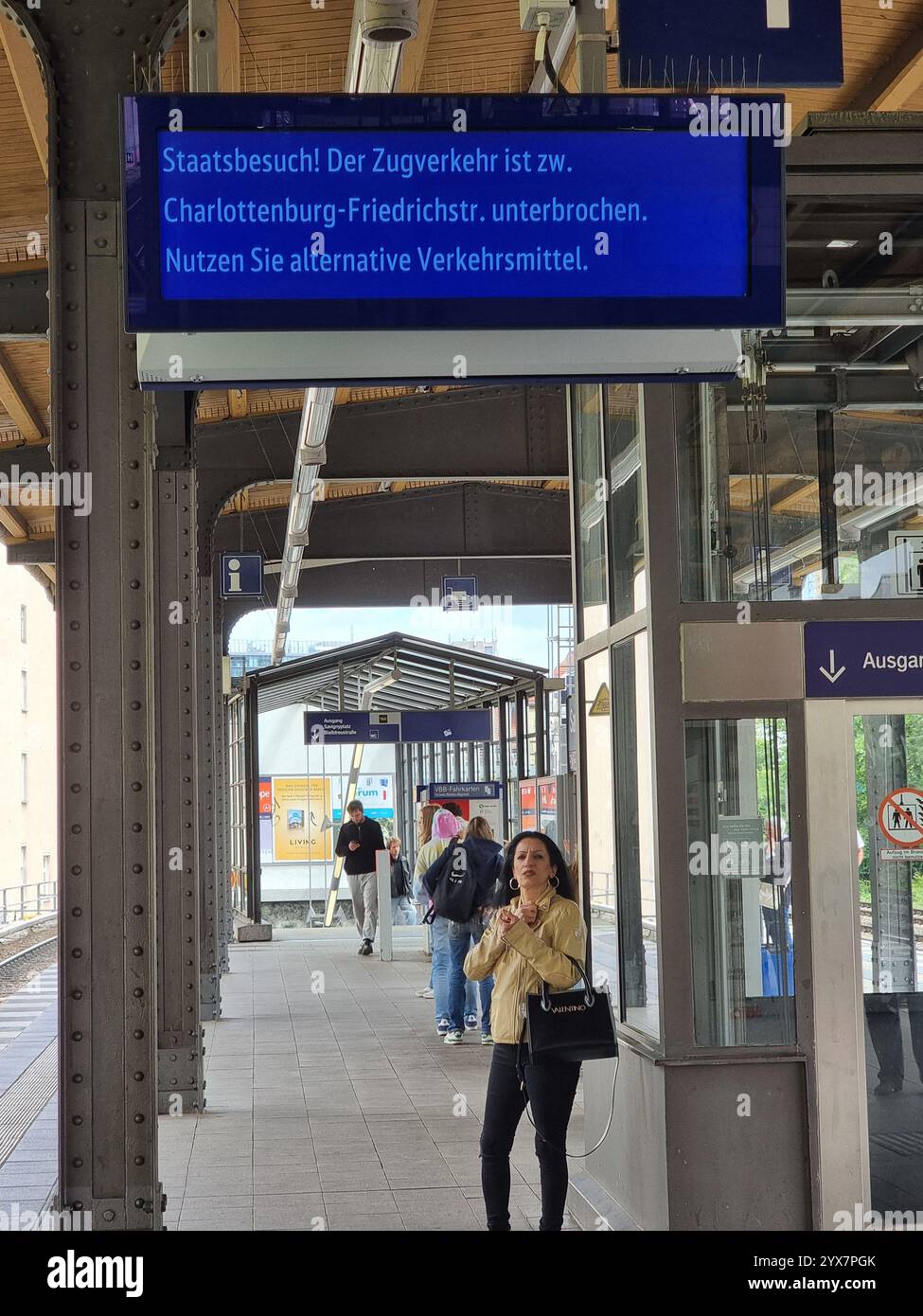 Female traveler looking at display indicating interruption of public transportation S-Bahn in Berlin due to a state visit; Ukraine Recovery Conference - Smartphone Captured Stock Image