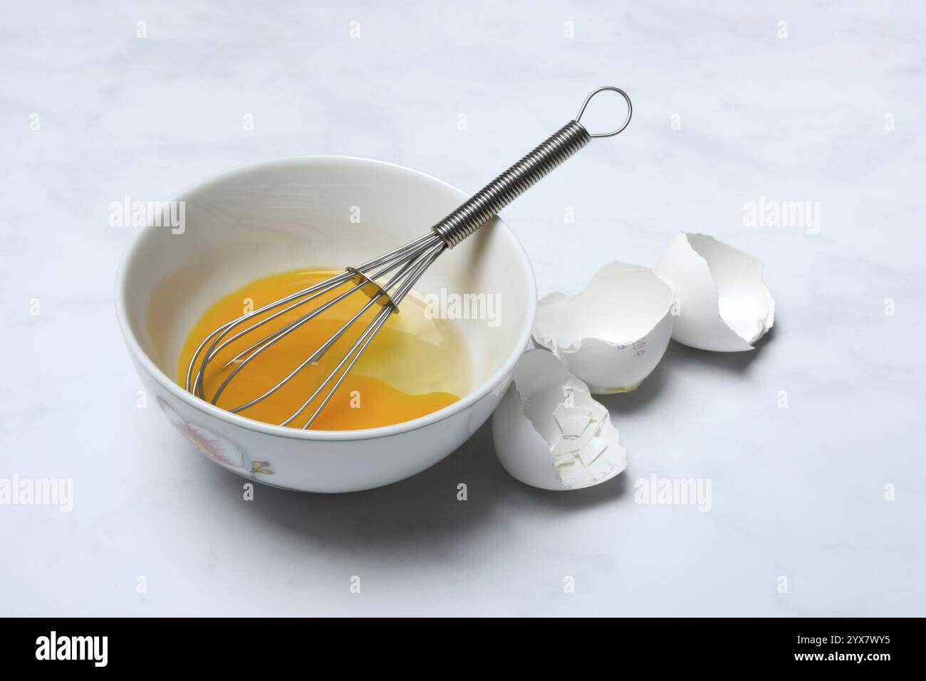 Whipped egg in shell with whisk, egg shells Stock Photo