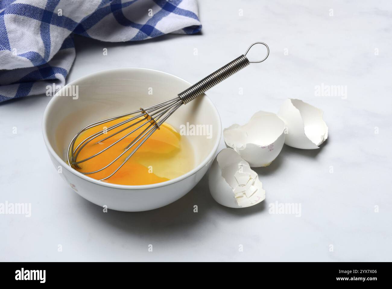 Whipped egg in shell with whisk, egg shells Stock Photo