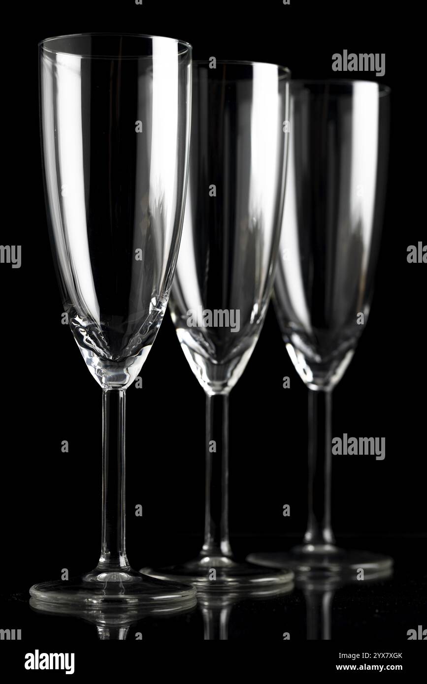 Three empty champagne glasses against a black background Stock Photo