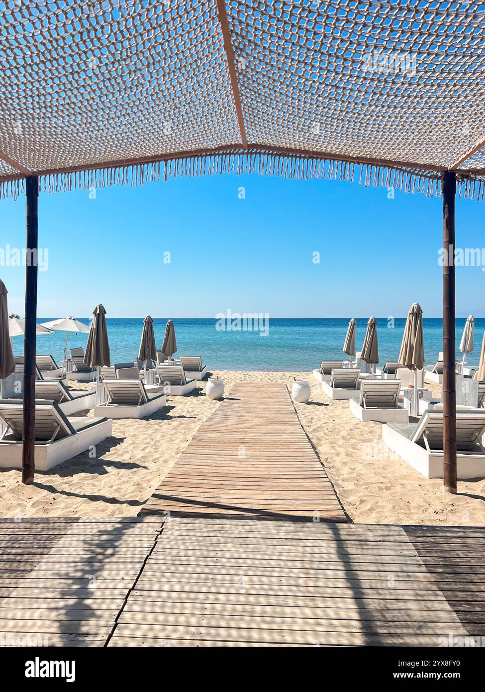 Beach bar with umbrellas in Greece at summer time - Smartphone Captured Stock Image