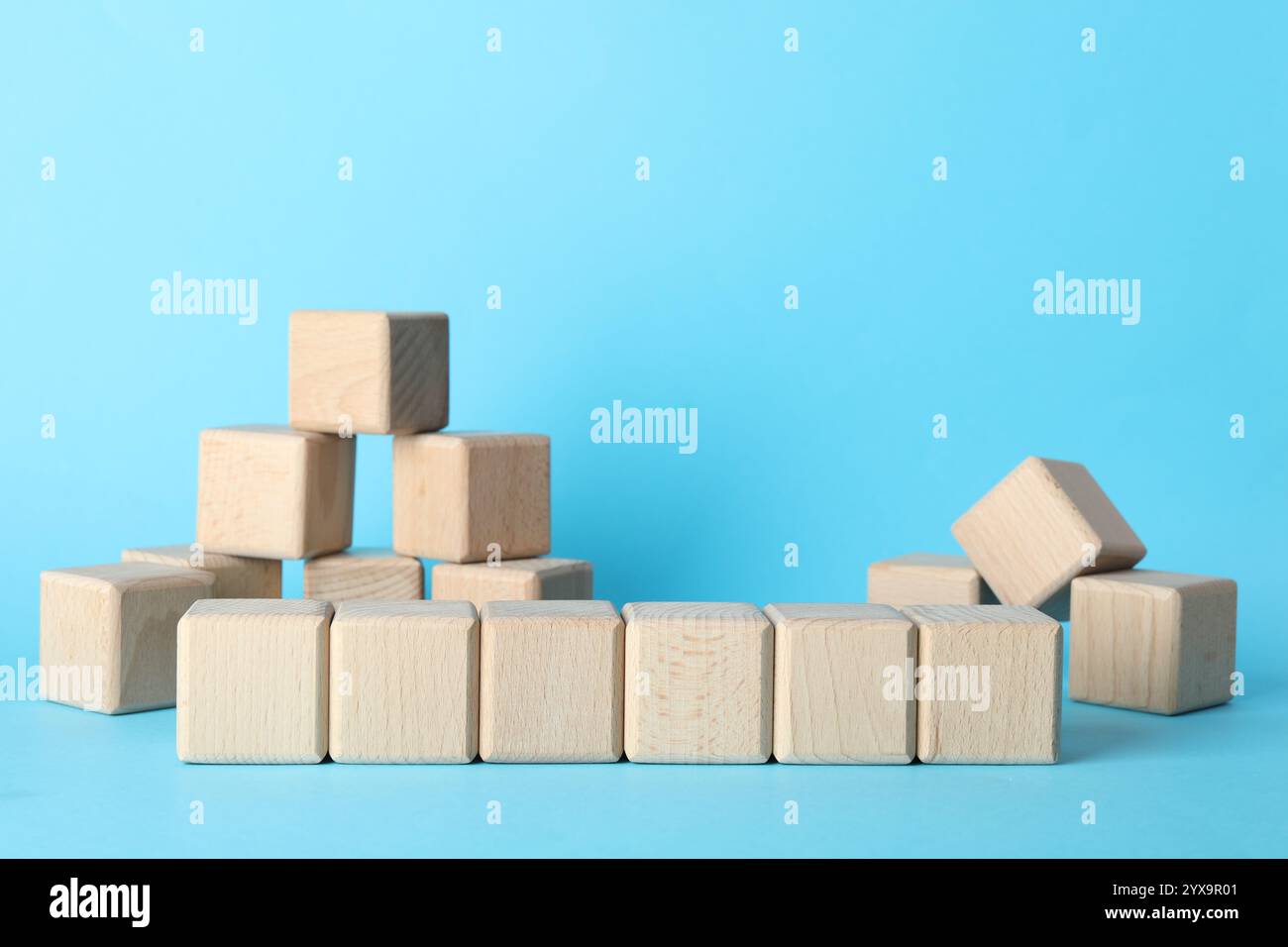 Many wooden cubes on light blue background Stock Photo - Alamy