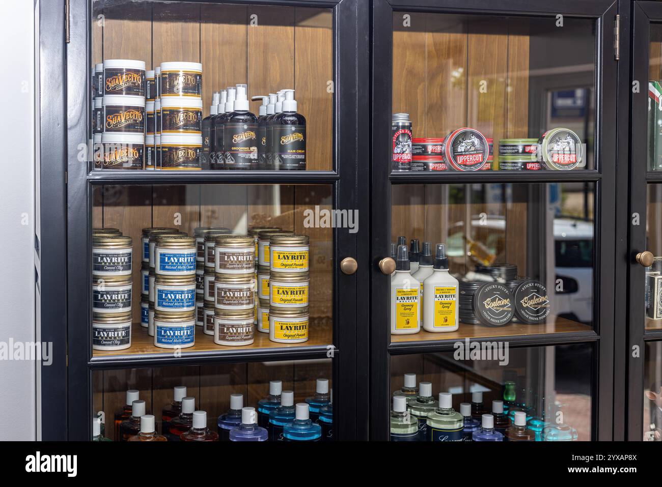 A close-up of a black display cabinet in a barber shop showcasing beard ...