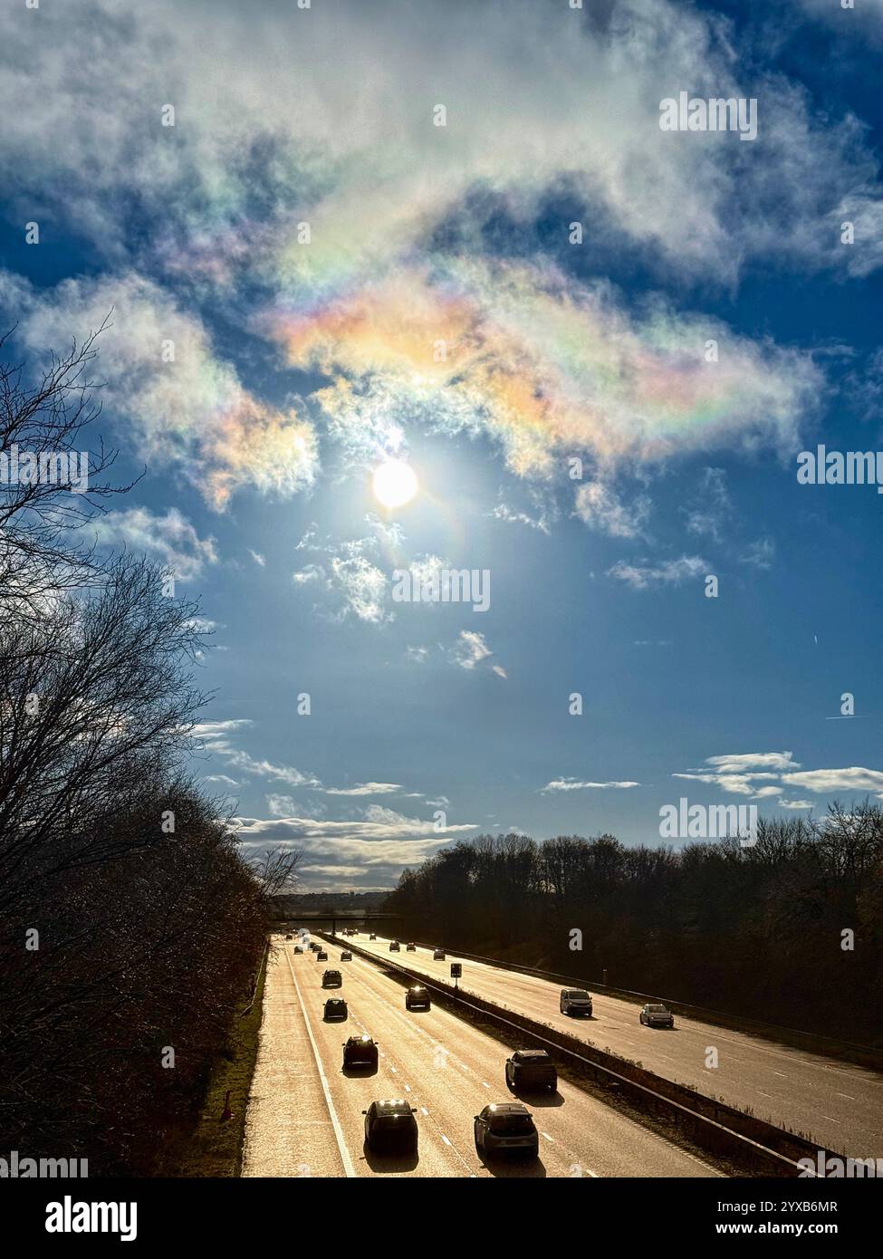Aerial view from bridge looking into the sun of the M61 motorway at Adlington near Chorley in Lancashire with vehicles silhouetted against the light. - Smartphone Captured Stock Image