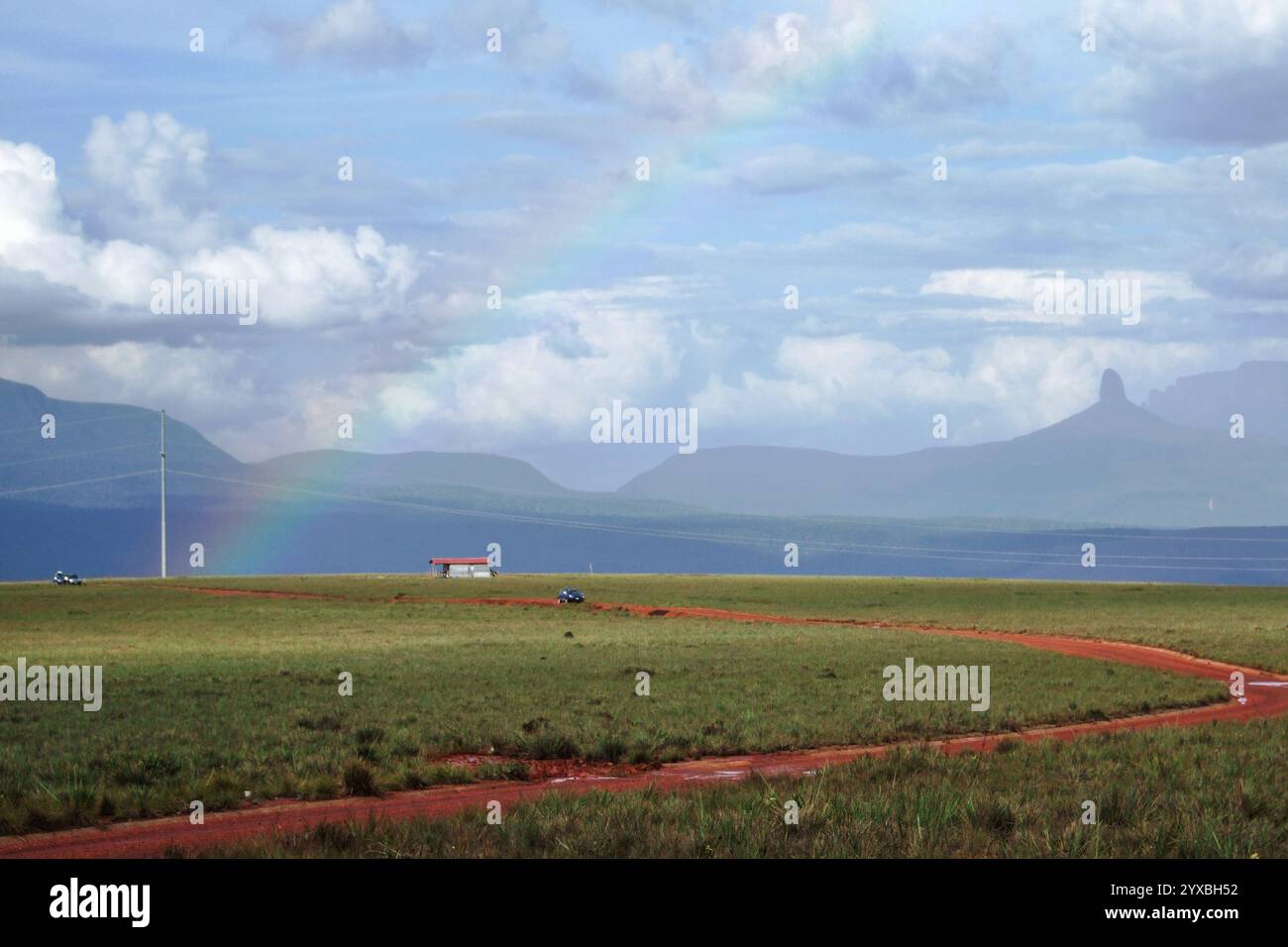 Rainbow view of dirt road and tepui mountains across savannah, Gran Sabana, Bolivar State, Venezuela, South America Stock Photo