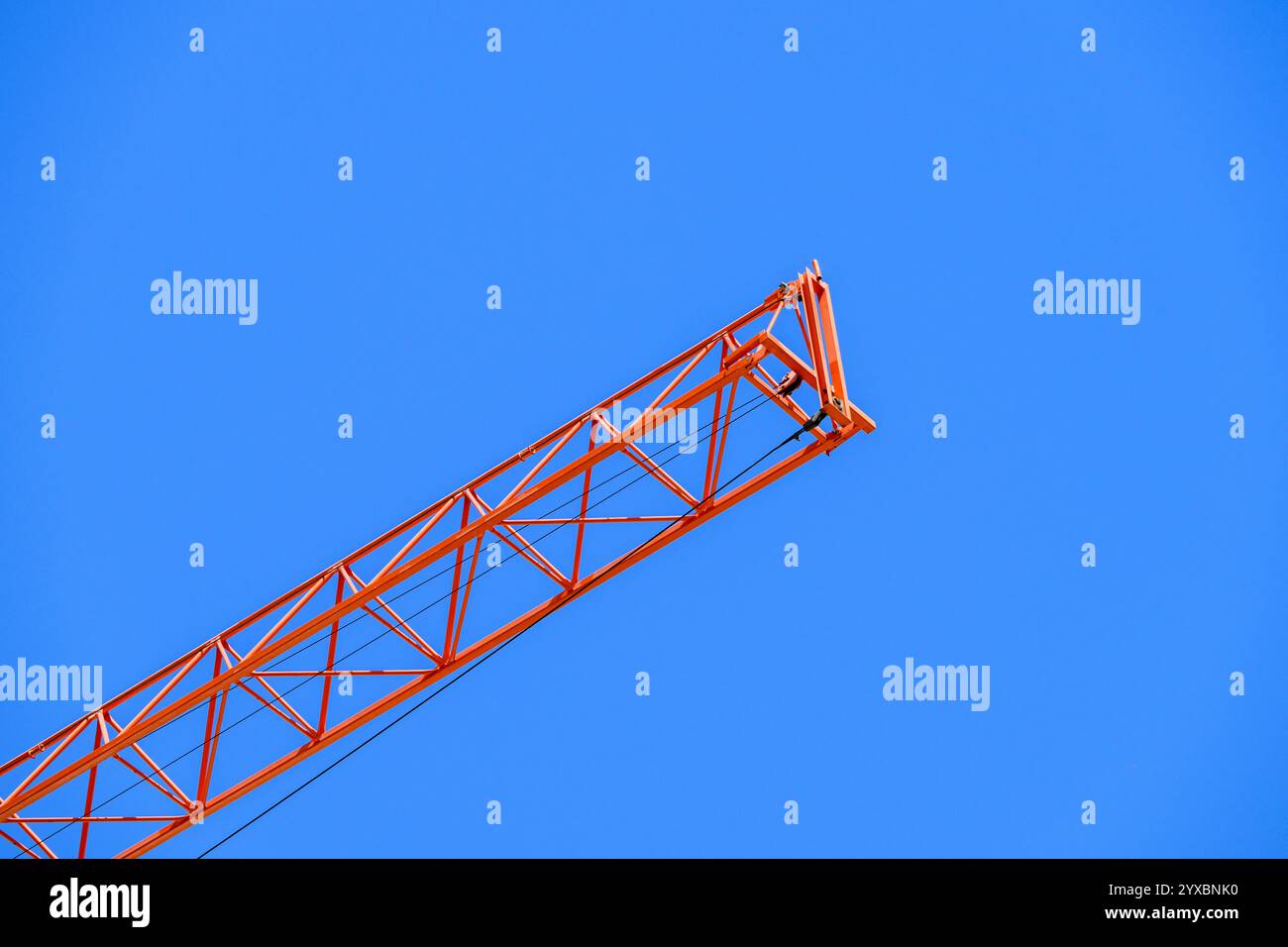 Red Construction crane against a blue sky Stock Photo