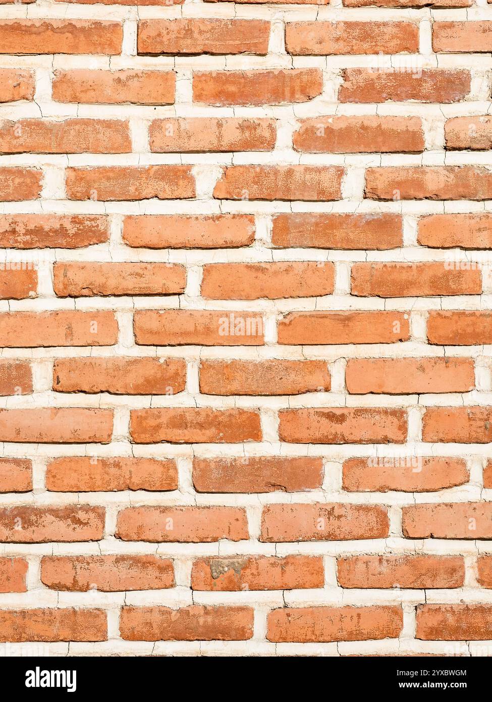 outdoor orange brick wall with clay seams on sunny day Stock Photo