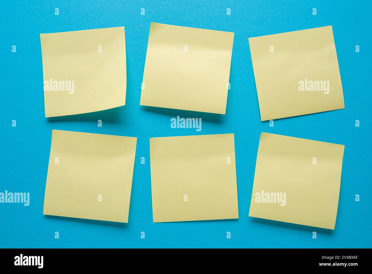 Blank sticky notes stuck in order on a blue background Stock Photo