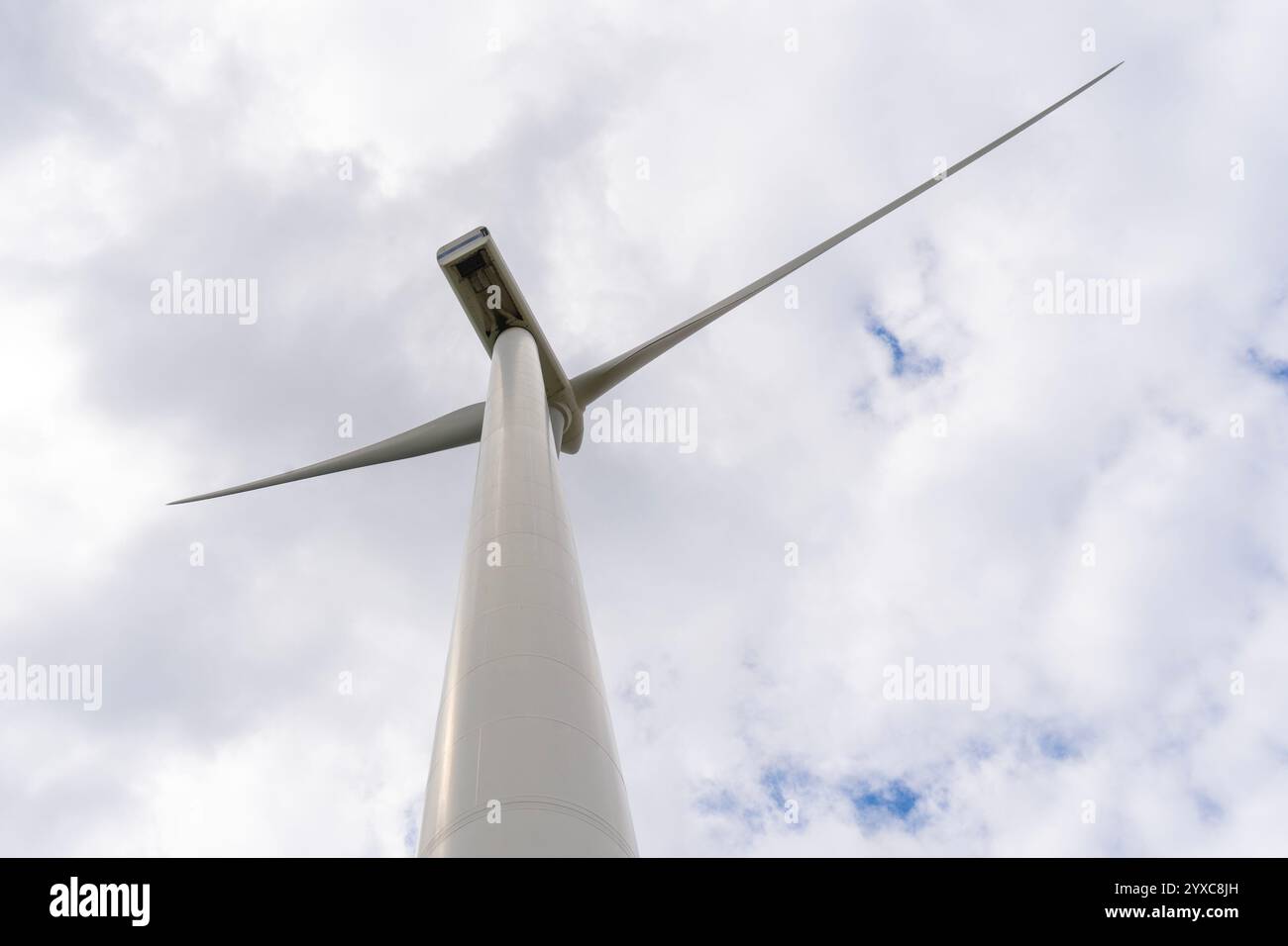 Wind turbine under cloudy blue sky Stock Photo - Alamy