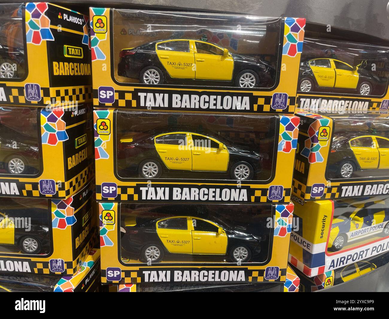Boxes of toy "Taxi Barcelona" cars, featuring black and yellow design, displayed on shelves, Barcelona Airport, Catalonia, Spain - Smartphone Captured Stock Image