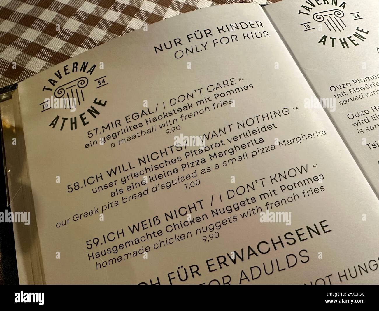 The kid's menu of a Greek restaurant with humorous names for kid's dishes in German and in English - Smartphone Captured Stock Image