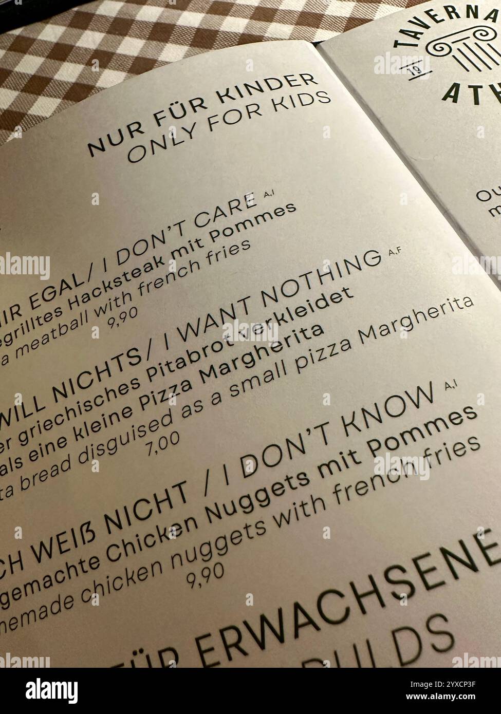 The kid's menu of a Greek restaurant with humorous names for kid's dishes in German and in English - Smartphone Captured Stock Image