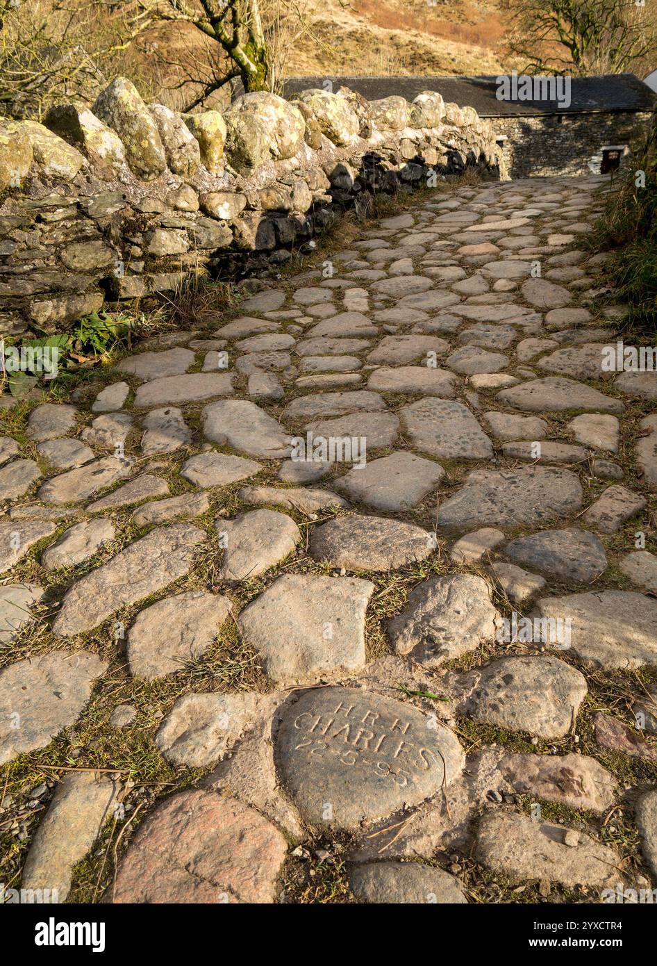 Engraved cobble-stone commemorating the visit of HRH Prince Charles in 1995 to see work on Watendlath pack-horse bridge, Cumbria, England, UK Stock Photo