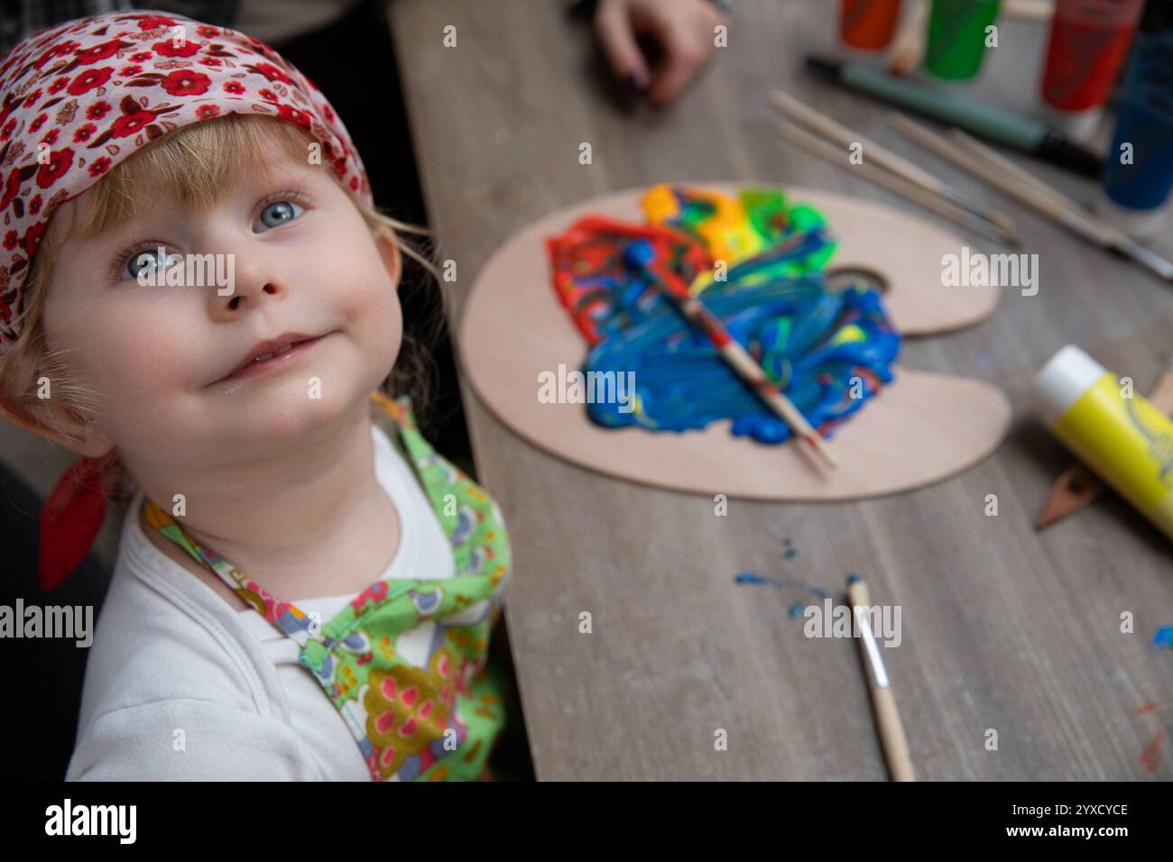 A child is engaged in the creative activity of painting using vibrant ...