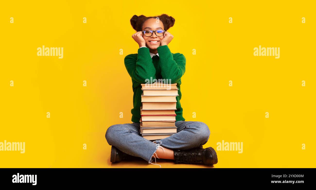 Afro schoolgirl with pile of books at studio Stock Photo - Alamy