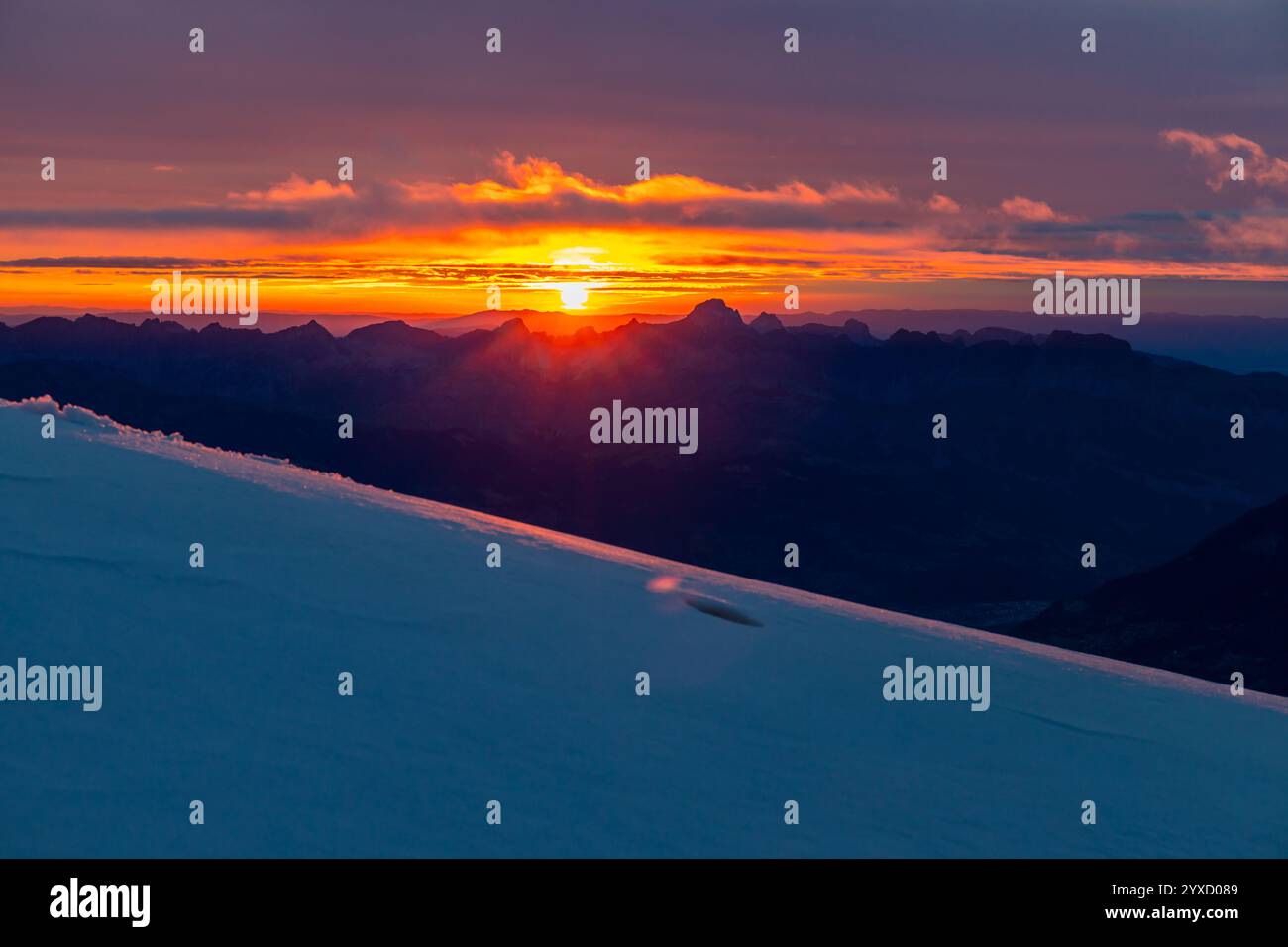 Sunset in the mountains. Red light on the sky with some clouds above ...